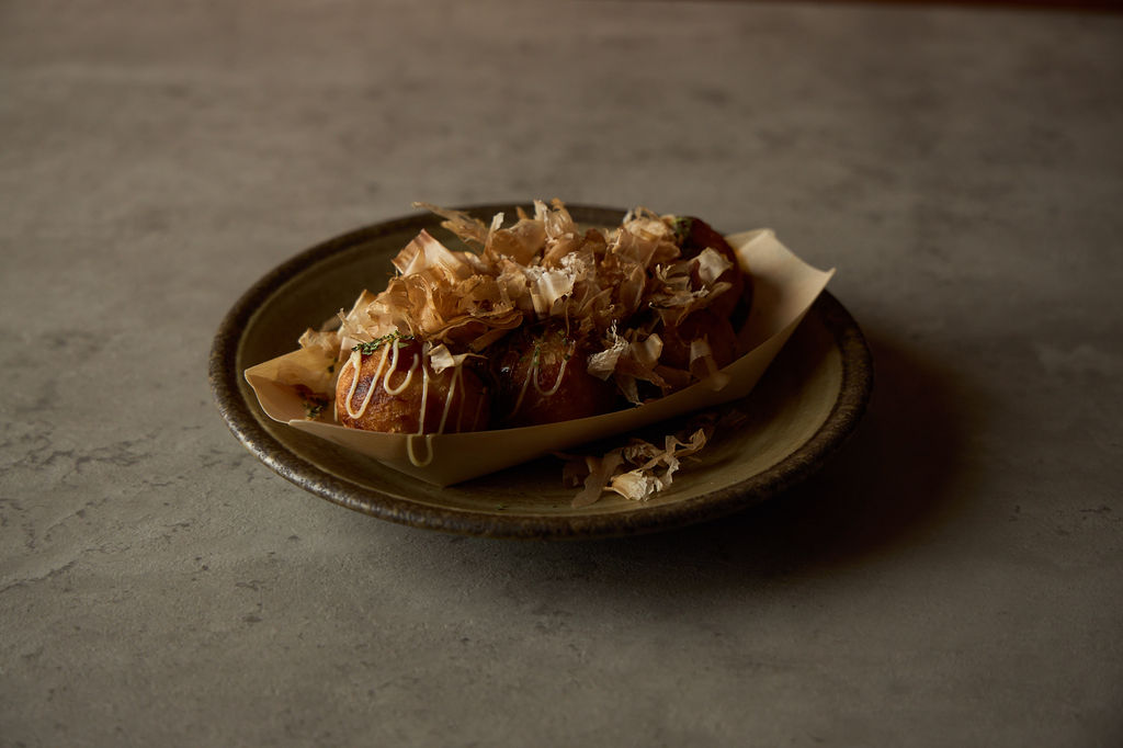 Takoyaki octopus balls topped with cascading bonito flakes, overhead view